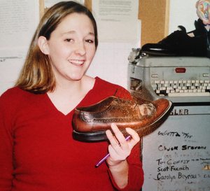 D.O.A.A. Board President Tiffany Lankes poses with the Shoe, out of which an incoming EIC drinks to kick off their tenure, in the management office of The Daily Orange in the early 2000s.