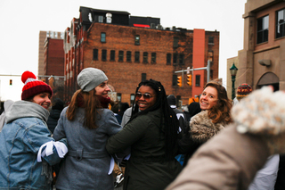 A group of women linking arm in arm smile for a photo during Friday's march.