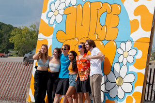 The painted Juice Jam logo is a fan favorite spot for taking photos. A group of students took a break from the concert to take their turn in front of the background.  